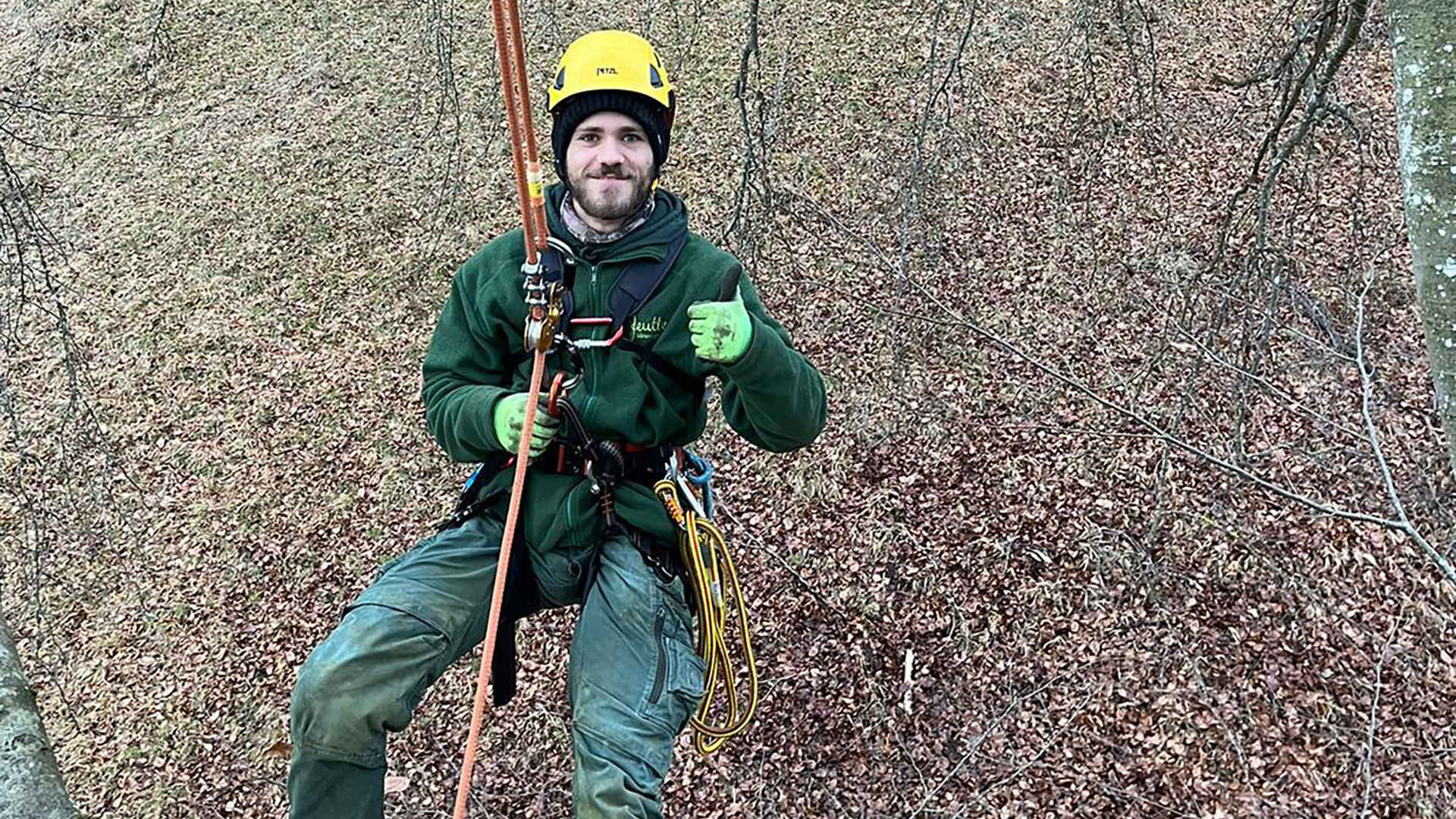 Moritz hängt gesichert an einem Baum