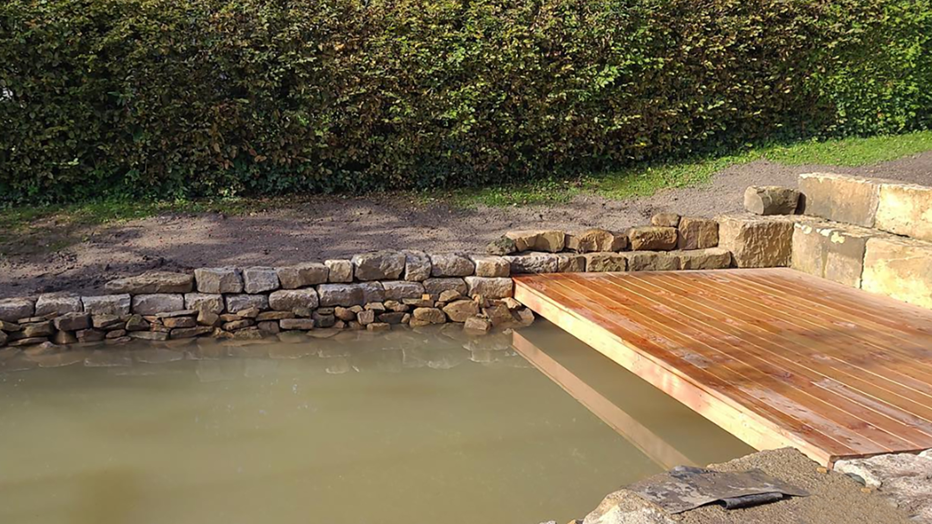 Natursteine auch als Mauer um einen Teich